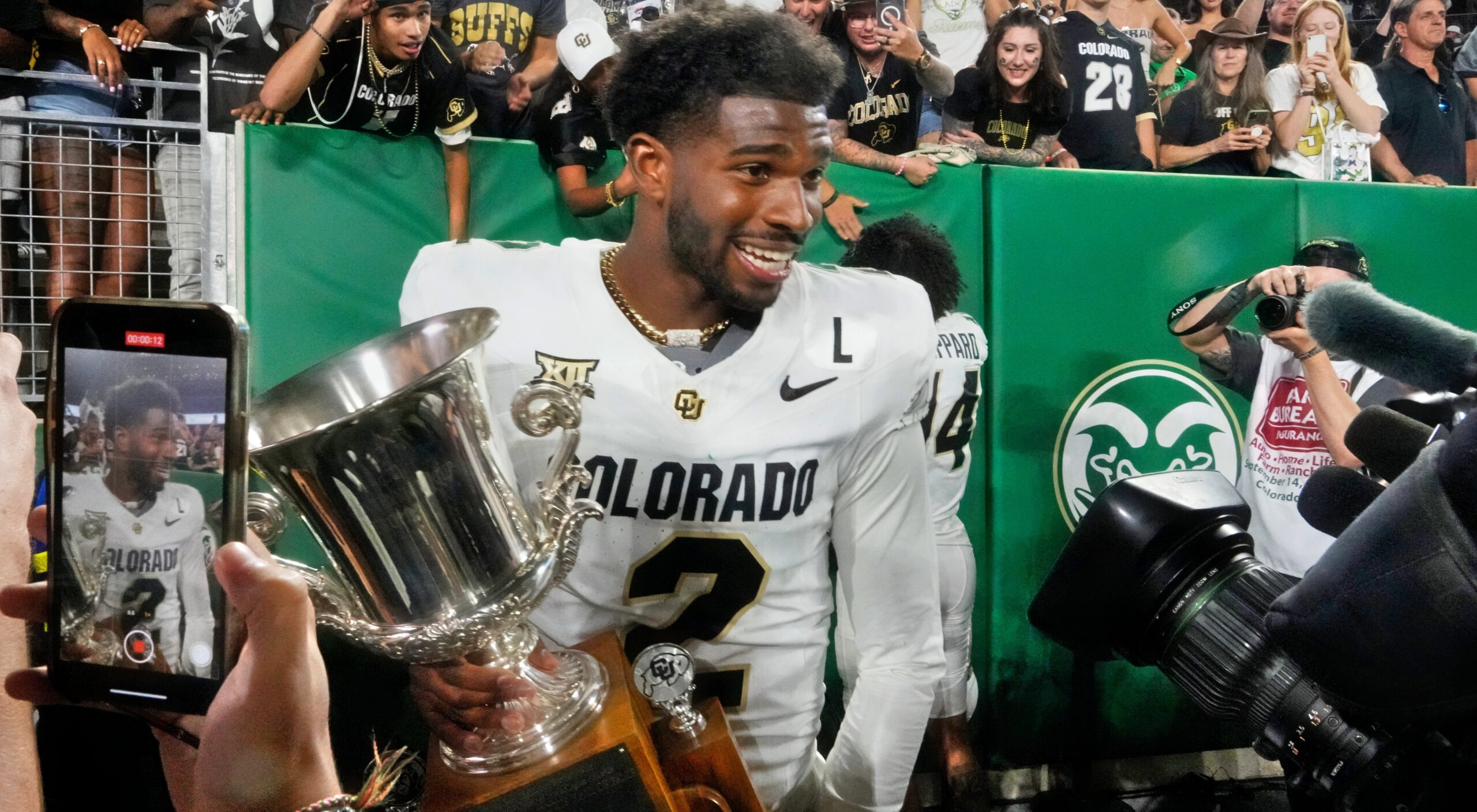 Shedeur Sanders holding trophy