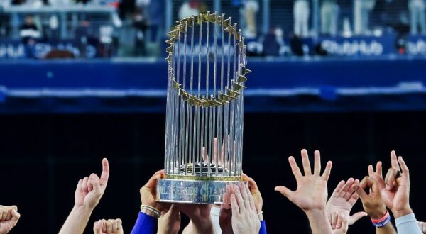 World Series trophy being held. Detroit Tigers legend Chet Lemon has passed away.