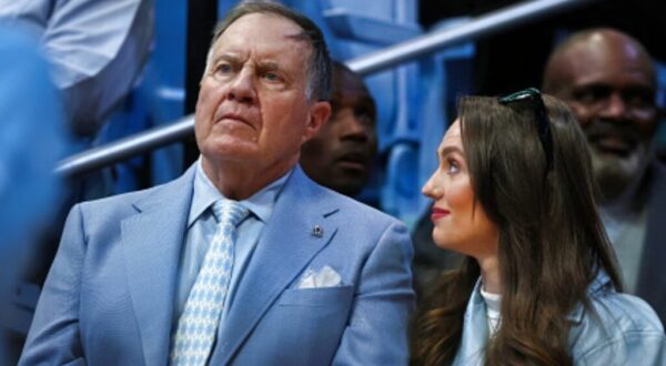 Bill Belichick standing next to Jordon Hudson