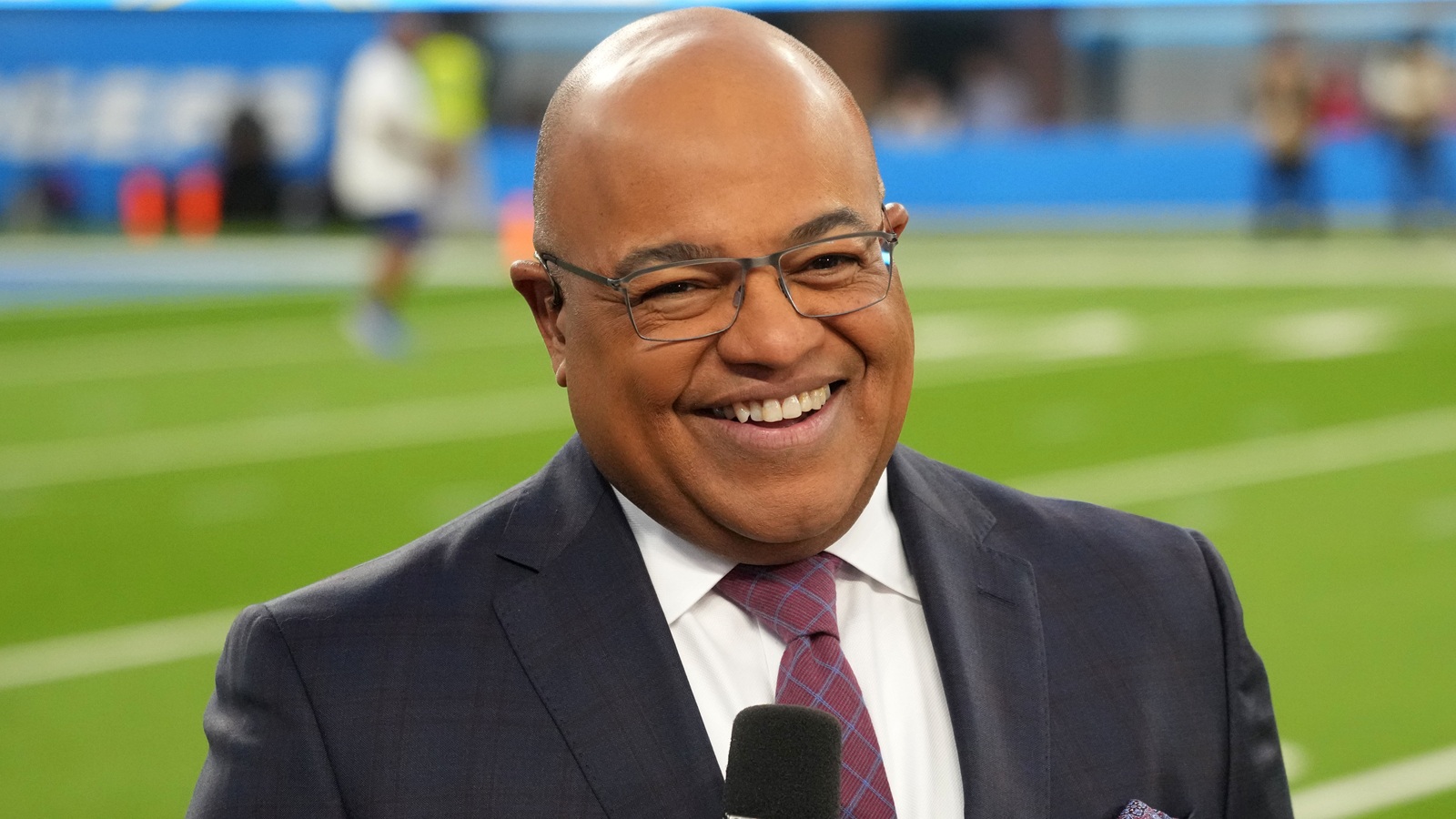 Mike Tirico smiling during a broadcast
