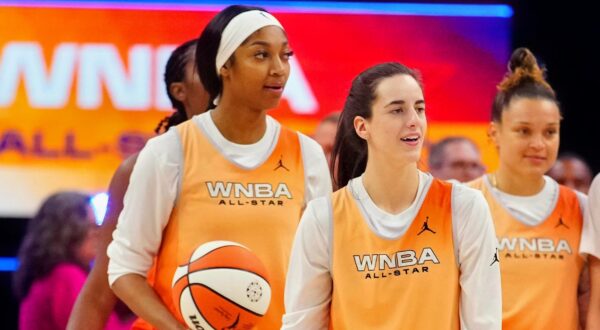 Angel Reese standing next to Caitlin Clark