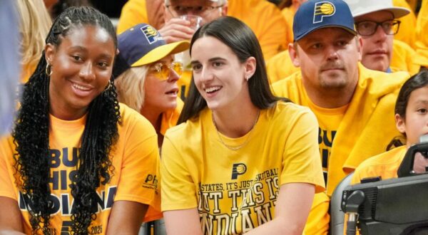 Caitlin Clark seated in crowd